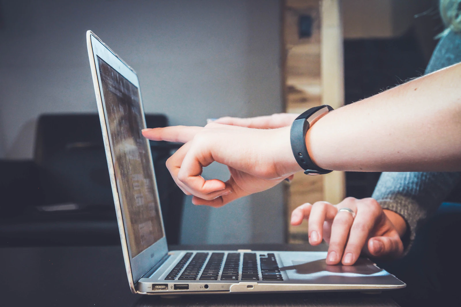 Two people reviewing application information together on a laptop