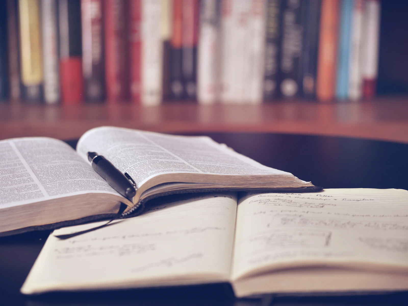 Open books and handwritten study notes arranged on a library table